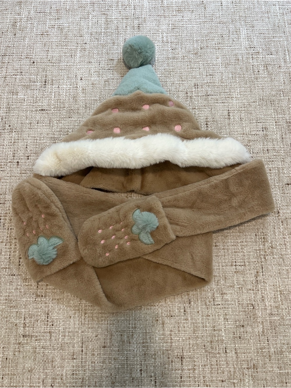 Brown faux fur hat with white trim and pink polka dots